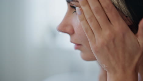 Señora-Tranquila-Limpiando-La-Cara-En-Casa-De-Cerca.-Mujer-Satisfecha-Salpicando-Agua-En-La-Piel