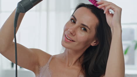 Charming-girl-styling-hair-at-home-pov-view.-Woman-brushing-chevelure-portrait