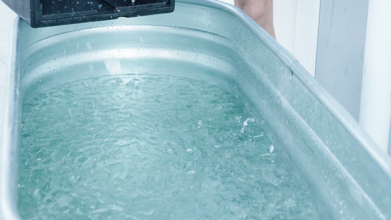 Vídeo Premium - Poner cubitos de hielo en una tina de baño de hielo con agua