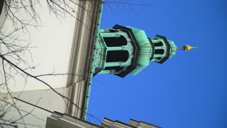 Toma-Vertical-De-La-Histórica-Torre-De-Color-Verde-Lavada-Desde-Abajo-Con-Una-Espiga-Dorada-En-La-Parte-Superior-En-La-República-Checa-Estilo-Romántico-Barroco-Elegante-Arquitectura-De-Antaño-Realeza-Princesa-Escondida-Dentro