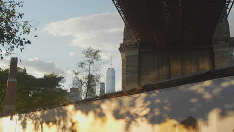 Freedom-tower-sits-behind-a-fence-near-the-Brooklyn-Bridge