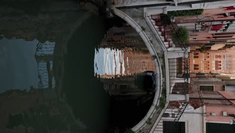 Toma-Vertical-De-Una-Mujer-Posando-Y-De-Pie-En-El-Puente-Sobre-El-Canal-En-Venecia,-Italia