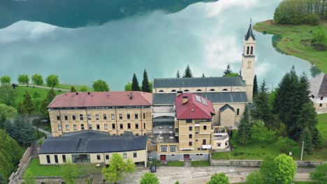 Iglesia-Junto-Al-Lago-Con-Reflejo-De-Nubes-En-El-Agua