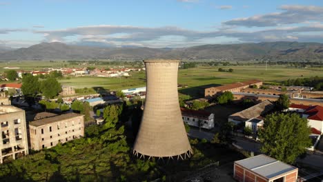 Tall-tower-of-coal-plant-station-on-an-abandoned-industrial-complex-with-ruined-buildings-in-Balkans