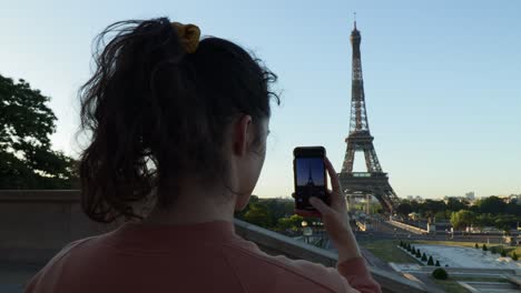 Nahaufnahme-Einer-Jungen-Attraktiven-Frau,-Die-Am-Frühen-Morgen-Im-Sommer-Mit-Ihrem-Telefon-In-Paris-Ein-Foto-Vom-Eiffelturm-Macht