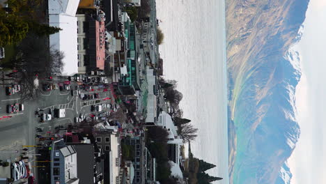 Aerial-view-of-tourists-and-traffic-Queenstown-center,-vertical-video