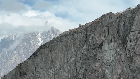 El-Carro-Aéreo-Se-Fue-A-La-Izquierda-A-Través-De-La-Pared-De-La-Montaña-Para-Revelar-Conos-Passu-En-El-Rango-De-Karakoram-Escondidos-En-Las-Nubes.