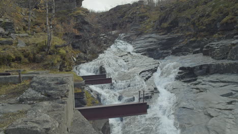 Multiple-streams-of-water-flows-in-slow-motion-with-metal-beams-in-foreground