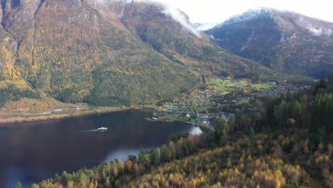 Stunning-footage-from-Kinsarvik-Norway-during-fall-season-with-snow-in-mountains-and-orange-leaves-on-trees---Electric-ferry-Kinsarvik-from-Boreal-company-sailing-to-port-in-the-Kinsarvik-Bay