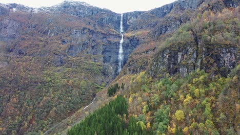 Skrikjofoss-waterfall-falling-455-meters-down-from-mountaintop-above-the-village-of-Lofthus-in-Hardanger-Norway---Autumn-aerial-looking-towards-beautiful-waterfall
