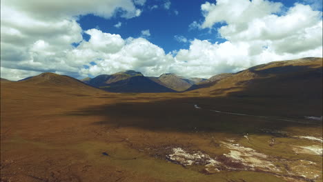 Flache-Felder-Mit-Bergen-Im-Hintergrund,-Skye,-Schottland,-Luftbild