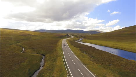 Viaje-En-Coche-Oscuro-En-La-Carretera-En-Escocia,-Tiro-De-Seguimiento-De-Drones-Aéreos