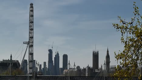 London-Eye-Spinning-with-trains-going-over-the-Hungerford-Bridge,-London,-United-Kingdom