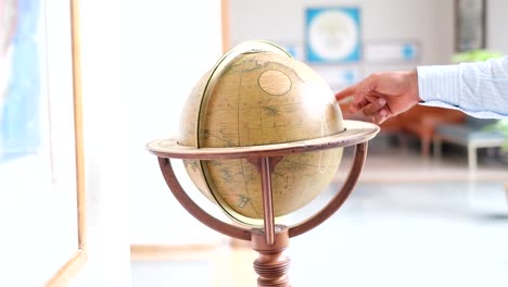 Antique-world-map-clock-running,-4k,-sliding-and-rotating-macro-close-upshot