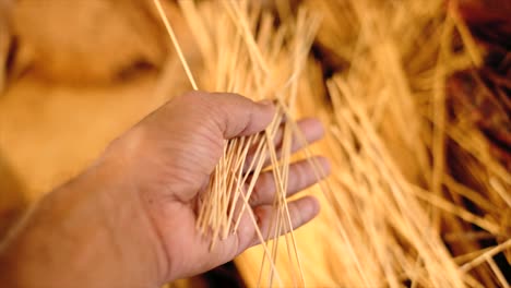 Detalle-De-Una-Mujer-Tocando-El-Arpa,-Materia-Prima-De-Joss-Stick-Con-El-Fabricante-Orgánico-En-India