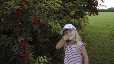 Cute-summer-girl-with-lovely-smile-wearing-Pippi-Longstocking-dress-picking-rowan-berries