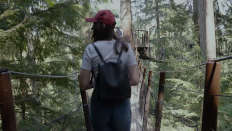 Folgen-Sie-Einer-Jungen-Wanderin,-Die-An-Einem-Schönen-Sommertag-über-Eine-Hängebrücke-Im-Wald-Geht