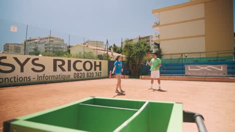 Tennis-coach-with-student-jump-to-hit-ball-with-powerful-racket-serve