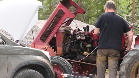 Toma-Estática-De-Un-Hombre-De-Mediana-Edad-Reparando-Un-Viejo-Motor-De-Tractor,-En-Un-Día-Soleado-De-Verano,-En-Ostrobotnia,-Finlandia