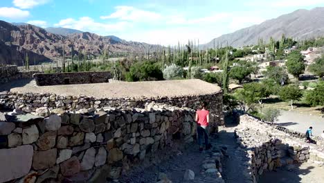 Wunderschöne-Landschaft-Der-Pre-inka-ruinen-Von-Pucara-De-Tilcara-An-Einem-Sonnigen-Tag-Und-Ein-Brünetter-Tourist,-Der-Durch-Seine-Pfade-Geht