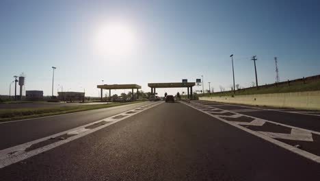 Driving-on-a-highway-and-passing-the-toll-booth-on-a-beautiful-sunny-afternoon