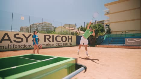 Tennistrainer-Demonstrieren-Einen-Kraftvollen-Aufschlag,-Der-Den-Ball-Mit-Schläger-Schlägt