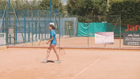 Chica-De-Tenis-Rebota-Una-Pelota-Con-Raqueta-Y-Se-Aleja,-Cámara-Lenta