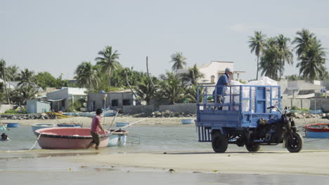 Fishermen-unloading-bags-of-motorbike-cart-and-placing-on-coracle-boat