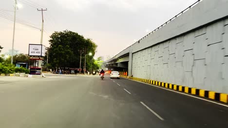 POV-of-a-driver-navigating-through-a-crowded-roadway-while-passing-numerous-cars-and-individuals-on-bikes