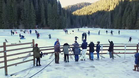 Gente-Que-Pasa-Tiempo-Libre-En-Un-Lago-Rojo-Congelado-En-Rumania-En-Una-Soleada-Mañana-De-Invierno---ángulo-Alto,-Toma-Amplia