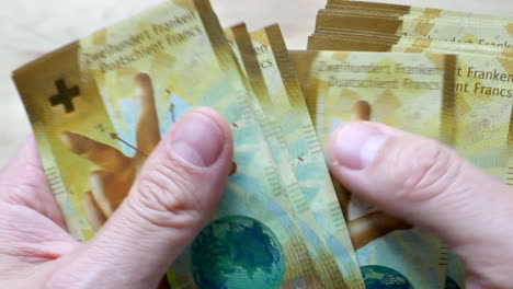 Cerca-Del-Hombre-Contando-Varios-Chf-Doscientos-Billetes-De-Francos-Suizos-En-Interiores-En-Casa