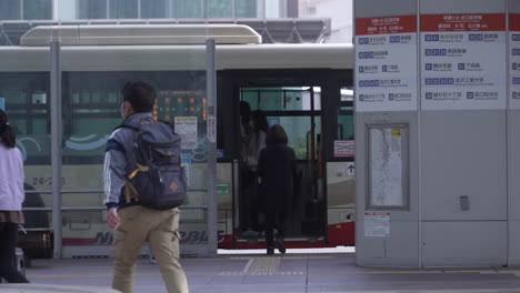 Passerby-With-Passengers-Getting-On-The-Bus-In-Kanazawa-City,-Japan