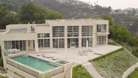 A-sweeping-aerial-view-of-a-modern-Beverly-Hills-Mansion-and-surrounding-grounds