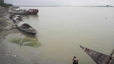 Una-Persona-Se-Baña-En-La-Orilla-De-Un-Río-Junto-A-Un-Barco