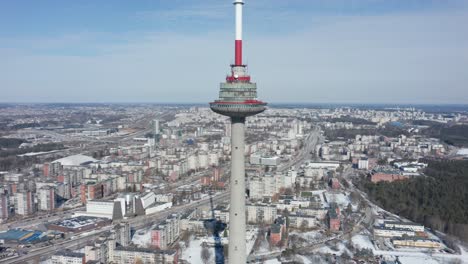 Rotierende-Luftdrohnenaufnahme-Des-Fernsehturms-Von-Vilnius-Mit-Der-Ganzen-Stadt-Vilnius,-Die-Ringsum-Sichtbar-Ist