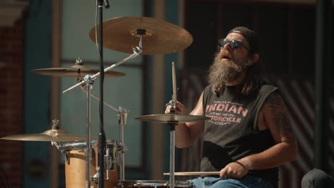 Old-man-with-long-beard-playing-drumset-on-parade-float,-Slow-Motion