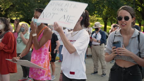 Woman-holds-REGULATE-GUNS-NOT-ME-protest-sign-at-reproductive-rights-rally-during-Women's-March-in-Austin,-4K