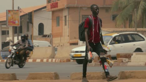 Vendedor-Ambulante-De-Electrónica-Masculina-Africana-Caminando-En-Cámara-Lenta---Togo,-áfrica