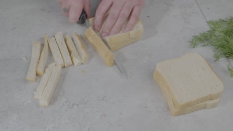 Static-Close-up-Shot-Of-An-Individual-Cutting-The-Crusts-Off-Of-Multiple-Slices-Of-Bread