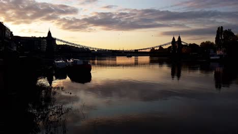 Río-Támesis-Al-Amanecer,-Con-El-Puente-Hammersmith-Al-Fondo