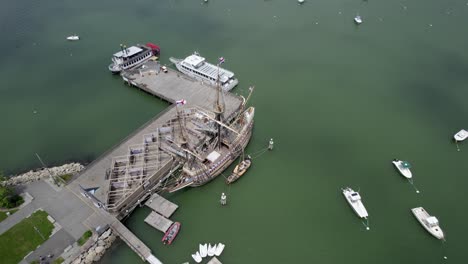 Mayflower-II-17th-century-ship-docked-at-the-town-of-Plymouth,-Massachusetts,-USA---high-angle,-orbit,-aerial