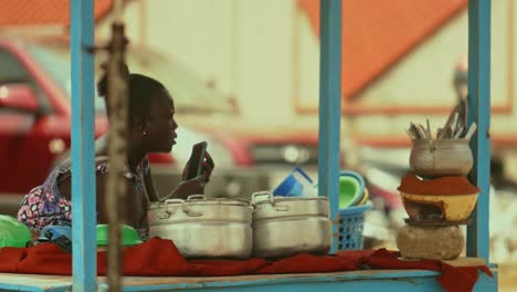 Vendedora-De-Comida-Africana-Haciendo-Un-Mensaje-De-Voz-Con-Su-Smartphone