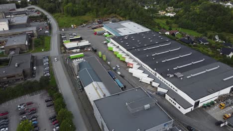 Bringen-Sie-Express-Terminalgebäude-Und-Lager-In-Nesttun-Außerhalb-Von-Bergen,-Norwegen---Luftaufnahme,-Die-Die-Gebäudehülle-Und-Viele-Im-Hub-Geparkte-Lastwagen-Zeigt