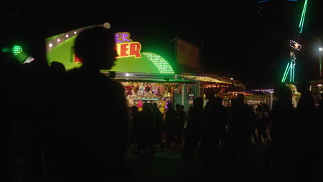 Crowds-of-people-walking-around-an-amusement-park-on-a-busy-evening