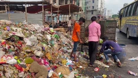 Workers-recycling-waste-from-van-at-urban-landfill