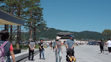 Korean-people-in-protective-face-masks-outdoors-while-traveling-at-Gwanghwamun-Plaza-with-view-on-Gwanghwamun-gate