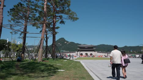 Los-Turistas-Coreanos-Pasean-Por-La-Plaza-De-Gwanghwamun,-El-Paisaje-Urbano-De-La-Puerta-De-Gwanghwamun-Contra-La-Montaña-Bugaksan---Espacio-De-Copia-Que-Establece-La-Toma