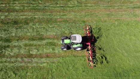 Tractor-Aéreo,-Máquina-Agrícola-Haciendo-Heno,-Conduciendo-Sobre-El-Campo,-Tiro-De-Arriba-Hacia-Abajo