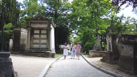 Aufnahme-Von-3-Touristen,-Die-In-Einer-Der-Gassen-Des-Friedhofs-Père-Lachaise,-Paris,-Frankreich,-Auf-Die-Kamera-Zugehen