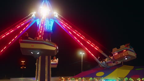 Neon-lights-flash-as-excited-people-enjoy-a-late-night-amusement-park-ride